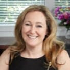 Smiling woman with blonde hair in a black top.