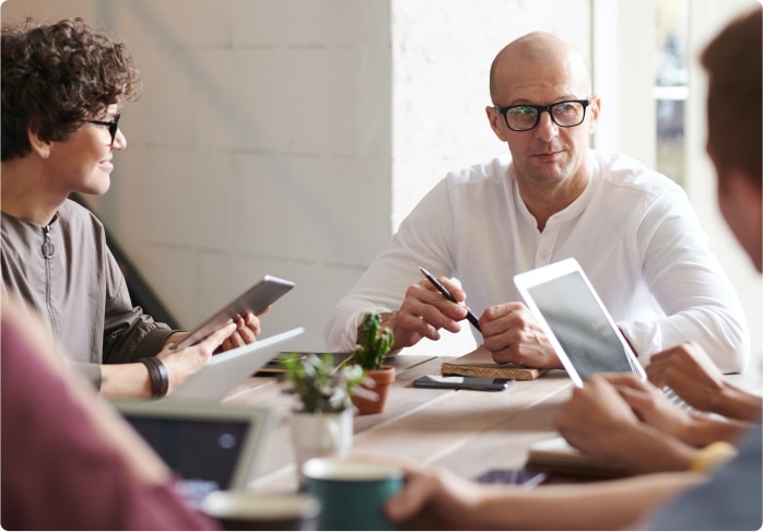 People in a business meeting using digital devices.